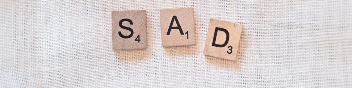 scrabble pieces spelling out sad