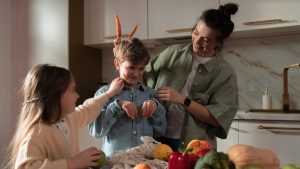 Mother and children have fun unpacking vegetables in the kitchen.