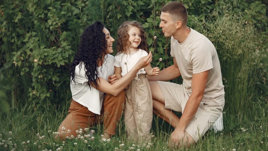 A joyful family enjoying time together in a lush green meadow, capturing love and bonding.